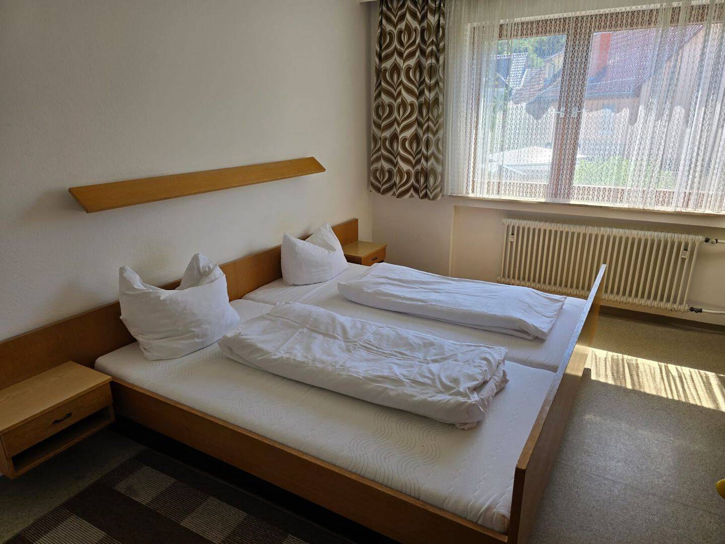 Möbliertes Zimmer mit Doppelbett und eigener Dusche